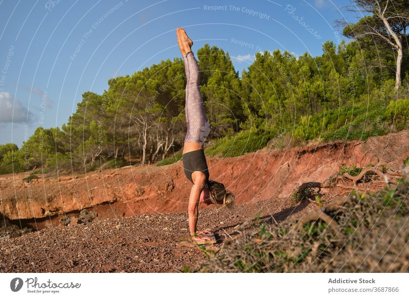 Woman in tights practicing handstand yoga in the middle of the forest natural vertical pose inverse fitness sport strength health woman girl healthy athlete