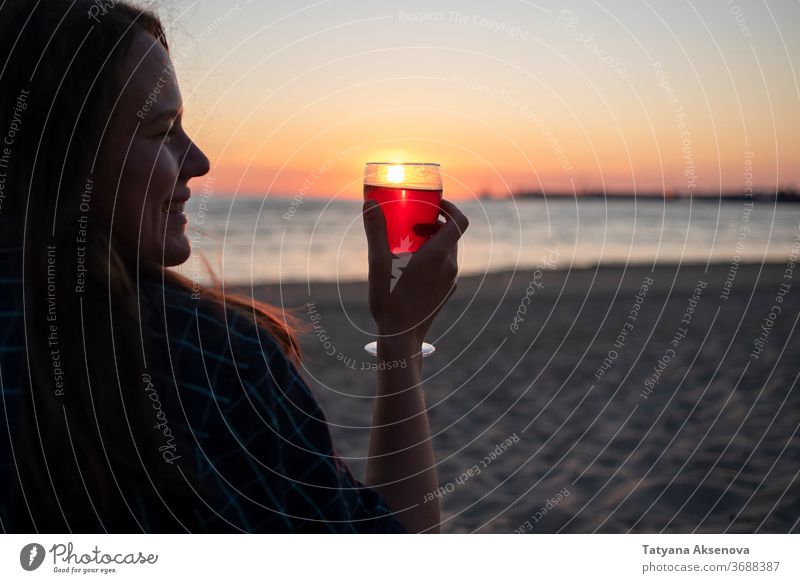 Woman with glass of wine on beach at sunset drink alcohol romantic enjoying slow living relax sea beautiful celebration beverage silhouette romance holiday
