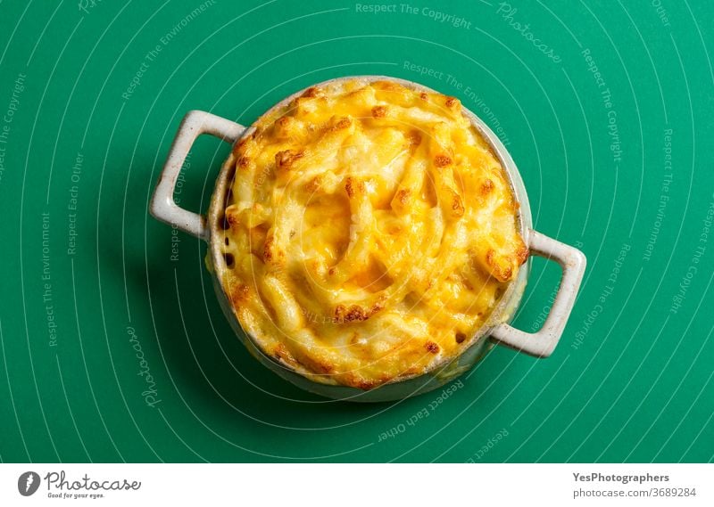 Mac and cheese bowl top view isolated on green background. Cheese macaroni above view carbs cheddar cheesy comfort food cooked copy space cream creamy cuisine