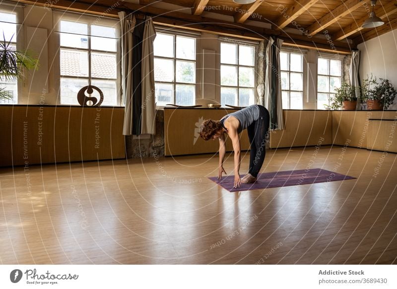 Woman practicing yoga in Halfway Lift asana woman practice stand halfway lift ardha uttanasana pose position wellbeing flexible female healthy concentrate