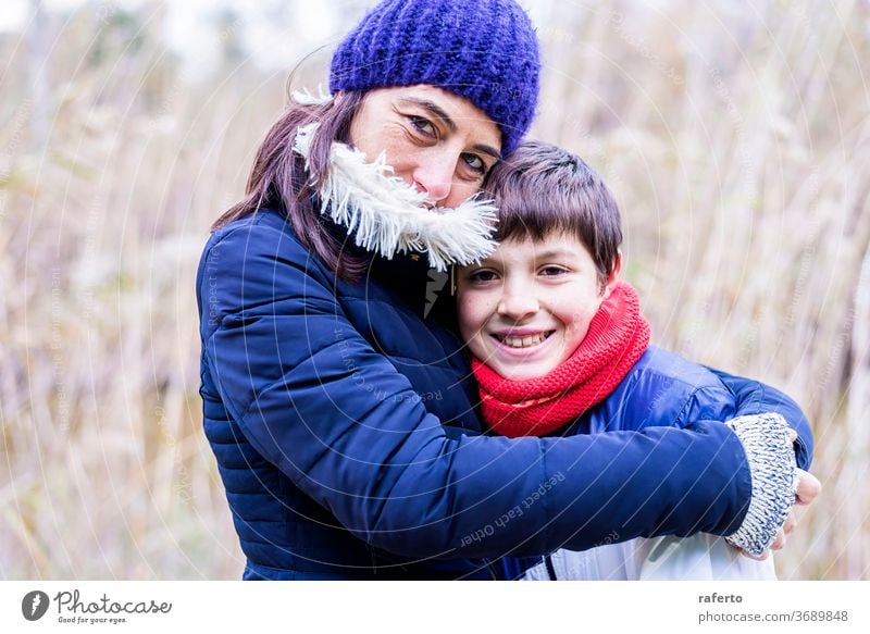 Mother with wool hat hugging son with love outdoors 2 caucasian young mother smiling people woman family cheerful beautiful senior lifestyle mature portrait