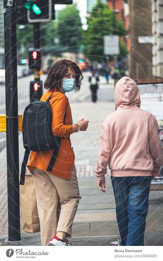 Mum and daughter in face mask are shopping uk new normal manchester england girl covering protection shops display windows lockdown empty city urban people