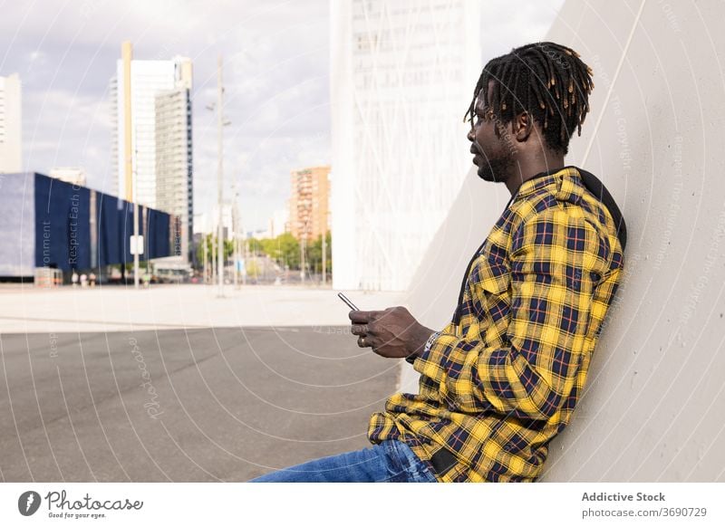 young african man with his phone on the city person holding black mobile technology male lifestyles modern cellphone smart smartphone urban american guy