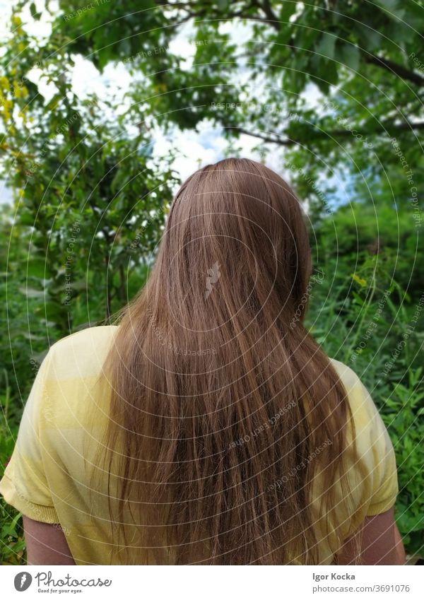 Rear View Of Woman Standing in Garden Rear view Trees Green Yellow Long-haired Head Upper body Brunette Shallow depth of field Central perspective Relaxation