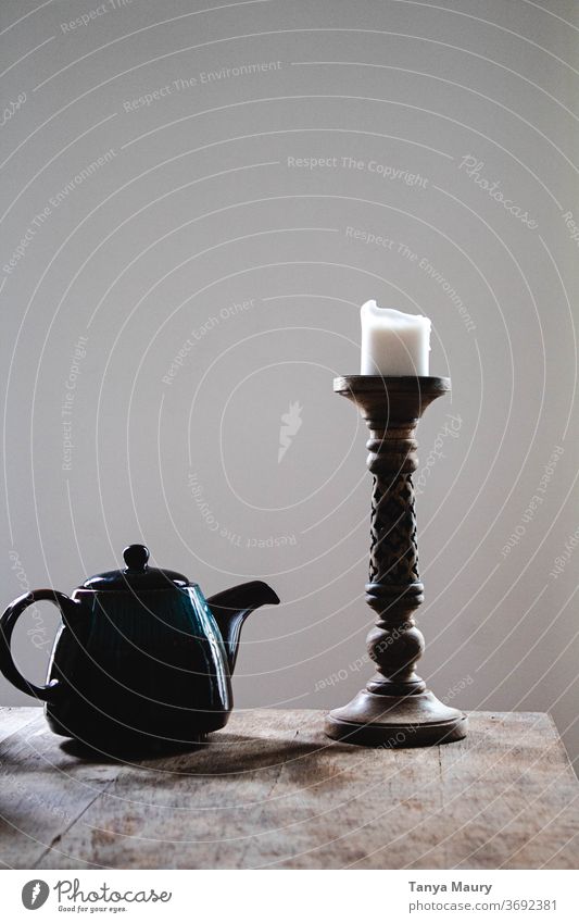 Blue teapot and white candle on a wooden table with a grayish background Teapot Candle Candlestick Wooden table Interior shot Lighting Decoration grey
