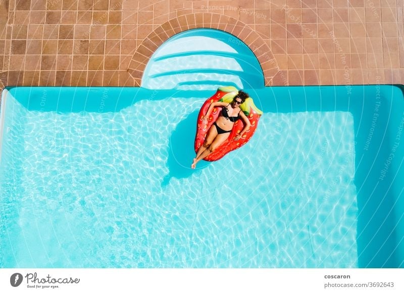 Woman floating on an ait mattress in a pool air beautiful bikini blue body cheerful copy copyspace drone enjoy enjoyment fashion female girl happiness holiday