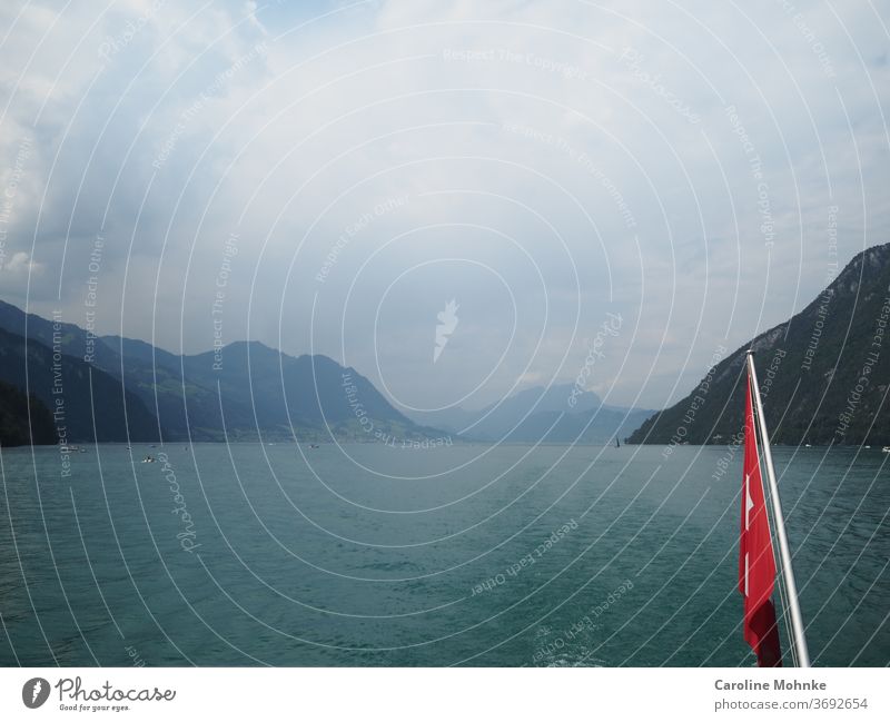 Mit dem Schiff gegen Flüelen /Schweiz Schifffahrt Schweizerfahne 1.August Nationalfeiertag Berge See Bergsicht schweizerisch Wolken Gewitter bewölkt Natur