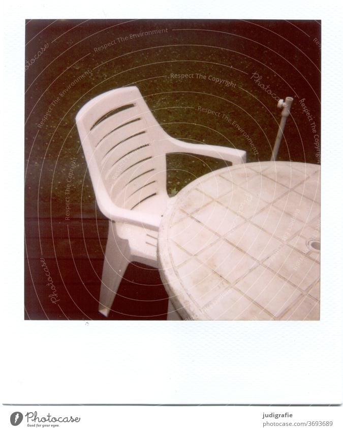 White garden chair with table on Polaroid Furniture Chair Garden chair Plastic chair Table Outdoor furniture Deserted Seating Exterior shot Colour photo Terrace