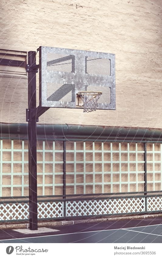 Outdoor basketball court by a building wall, New York. city sport outdoor hoop urban filtered retro USA no people NYC