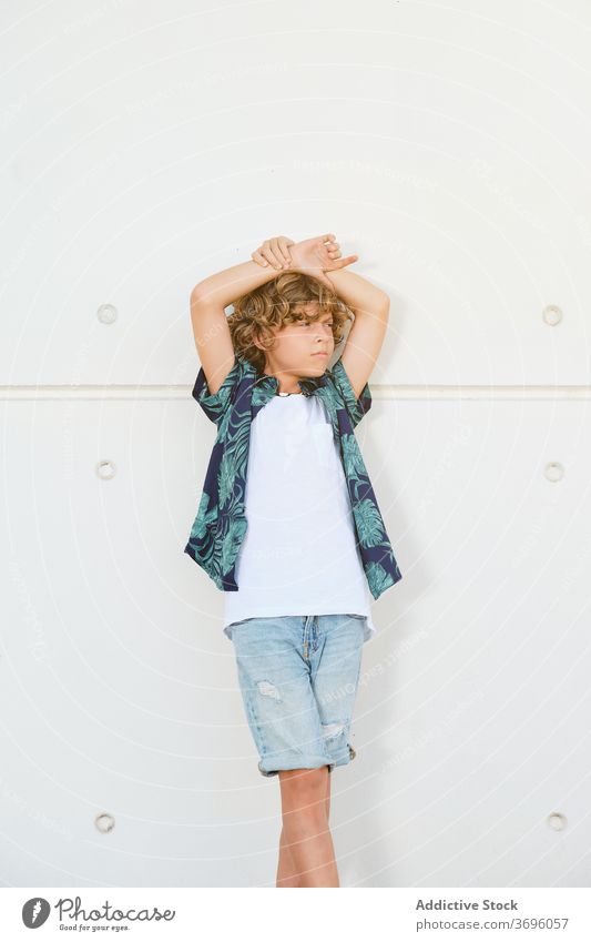 Caucasian boy with summer clothes posing outdoors vertical children confident arm positive shirt model expression standing youth contemporary confidence