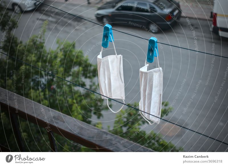 Washed surgical masks hanged up with pegs on the rope to dry corona coronavirus pandemic global new normal disinfectation protection face washed car