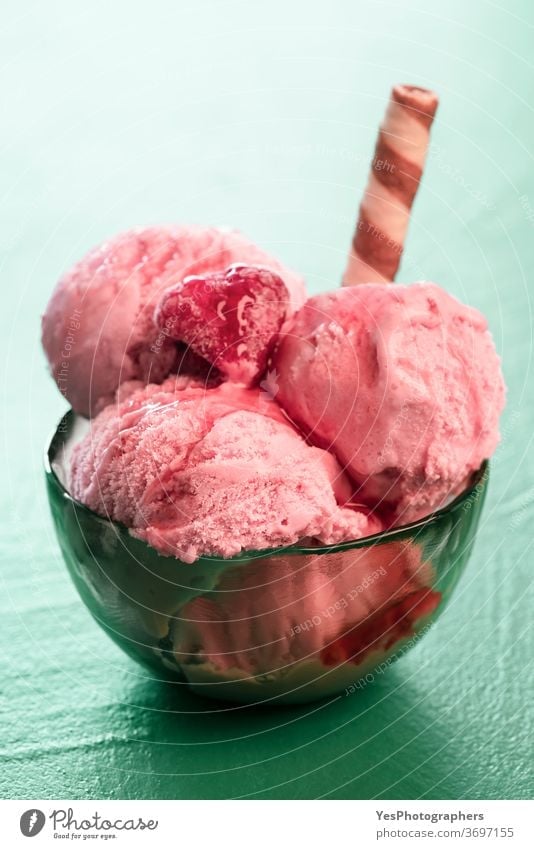 Raspberry ice cream close-up. Fruit ice cream in a bowl with toppings Italian appetizing ball berries bright colors cut out dairy delicious dessert detox diet