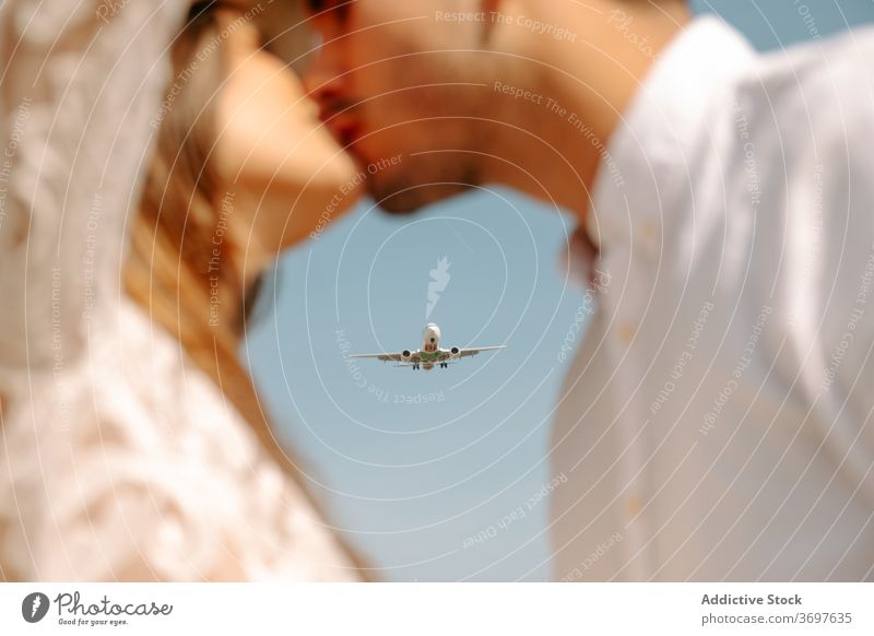 Newlywed couple kissing during romantic travel newlywed airplane relationship love honeymoon fly amorous fondness together married amour young bride groom happy