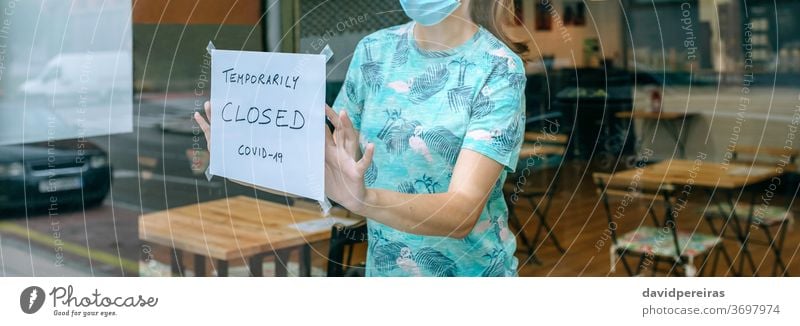 Woman placing coronavirus closure sign woman notice closing covid-19 coffee shop surgical mask sticking poster quarantine banner web header panorama panoramic