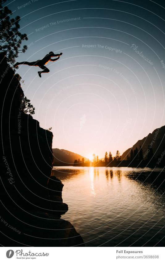 Man jumps off cliff at sunset over the beautiful Clark Fork River in eastern Montana national forest Forest Nature USA Vacation & Travel Mountain Landscape