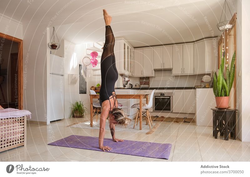 Woman doing the yoga handstands position in a house balance enjoyment exercising freedom relaxation routine simplicity spirituality mindfulness strength