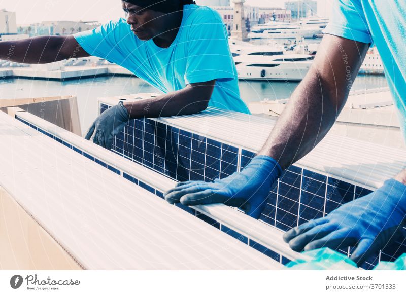 Black men with solar batteries panel install battery together work alternative energy resource ethnic black african american industrial area plant industry