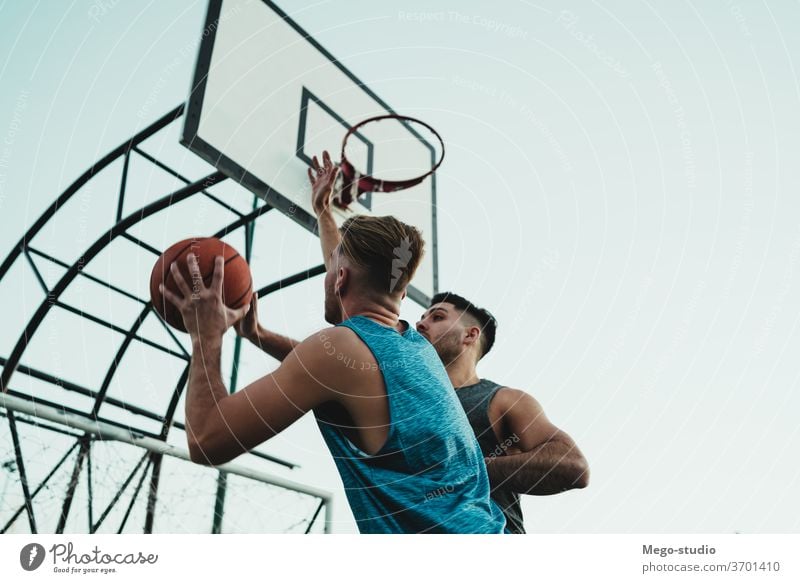 Young basketball players playing one-on-one. game youth sport court male young team together active action playground exercise men friendship jump happy athlete