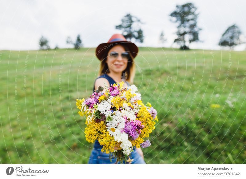 Young woman holding flower bouquet  in the field adult beautiful beauty bunch carefree casual charm colorful country cute environment fashionable female