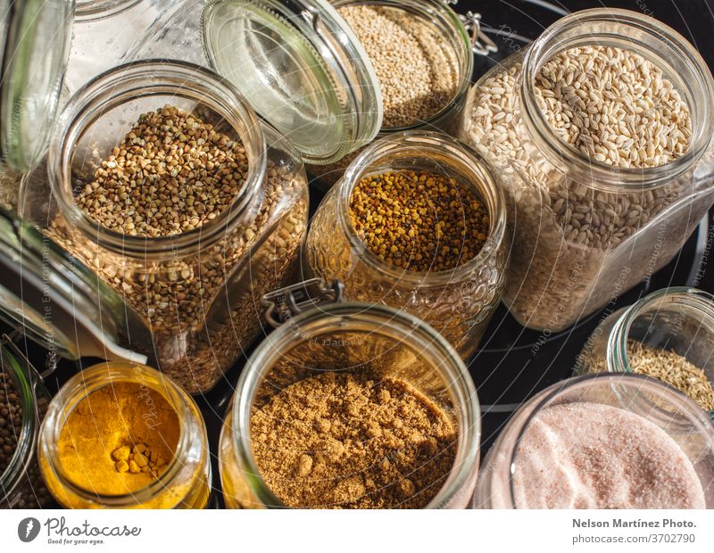 Close up shot of transparent jars of oats, salt, lentils, honey, rice, turmeric and panela. A close up shot of transparent jars of oats, salt, lentils, honey, rice, turmeric and panela