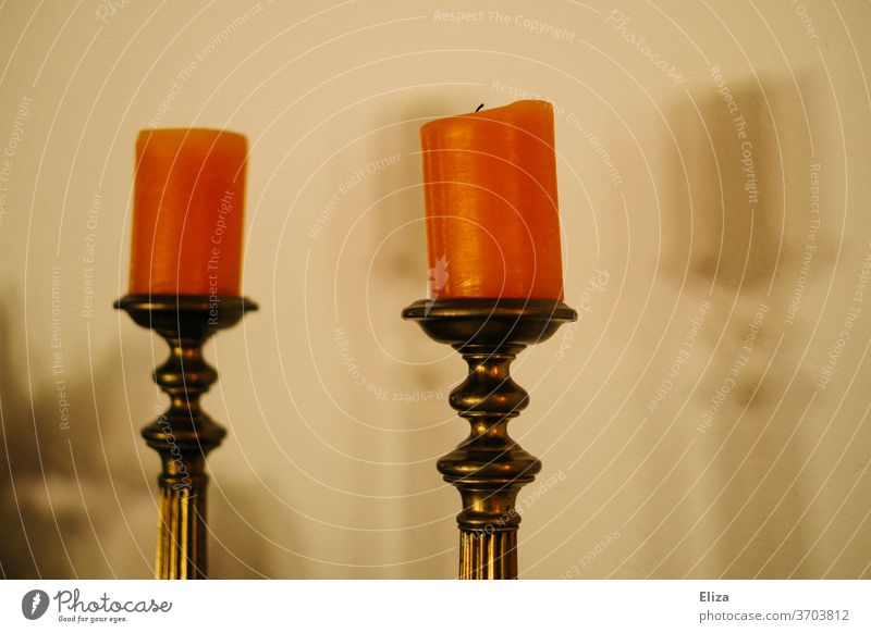Two orange candles on golden old-fashioned candlesticks two Orange Candle holder Old fashioned from unlit