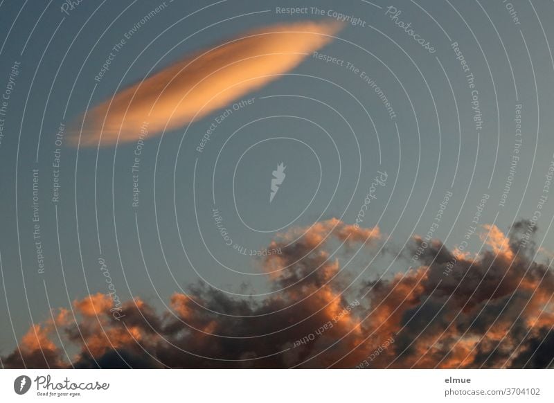 In the evening light a UFO suddenly appeared above the clouds illuminated by the setting sun fata morgana Evening optical illusion Exceptional Thermal Air layer