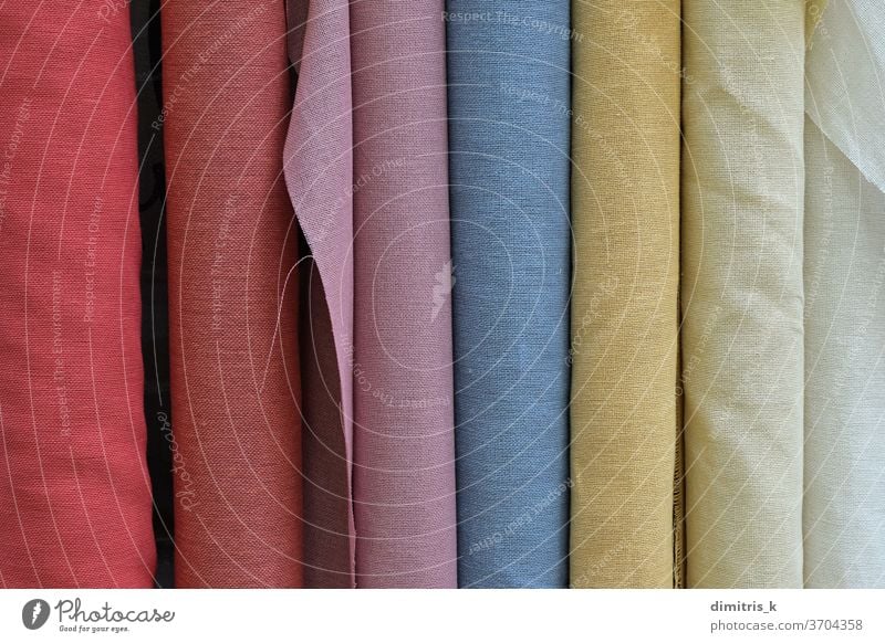 textile fabric material in various colors rolls background monochrome wholesale textured colorful rolled samples hue spectrum tint plain assorted textiles cloth