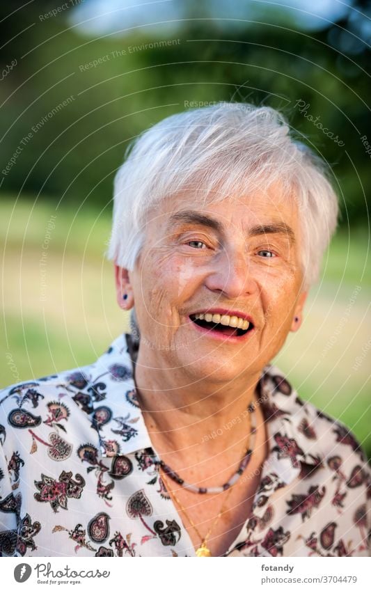 Happy pensioner Adult Spring Life Years of life Old age satisfied laugh Portrait Pensioner Head Face Elderly woman Female outside older Age glad alone green