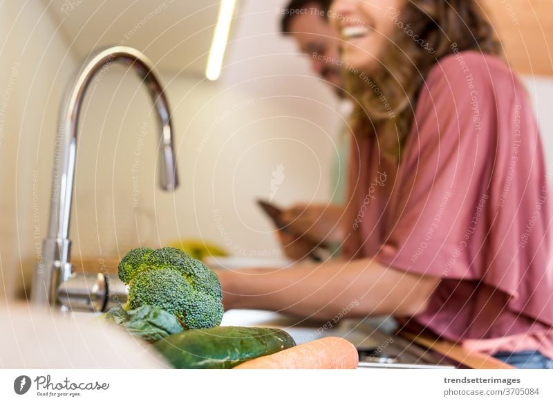 Young couple doing a delicious lunch smile eat indoors cruelty free vegan vegetarian tablet marriage cohabitation boyfriend attractive vegetable preparing
