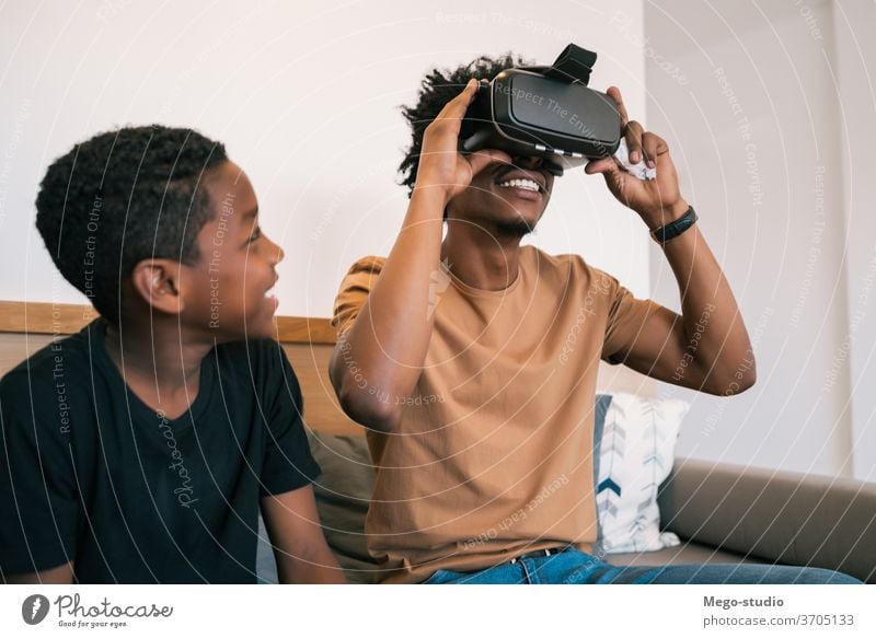 Father and son playing with VR glasses. father game video together african american relaxing adorable electronic relationship video game technology device hobby