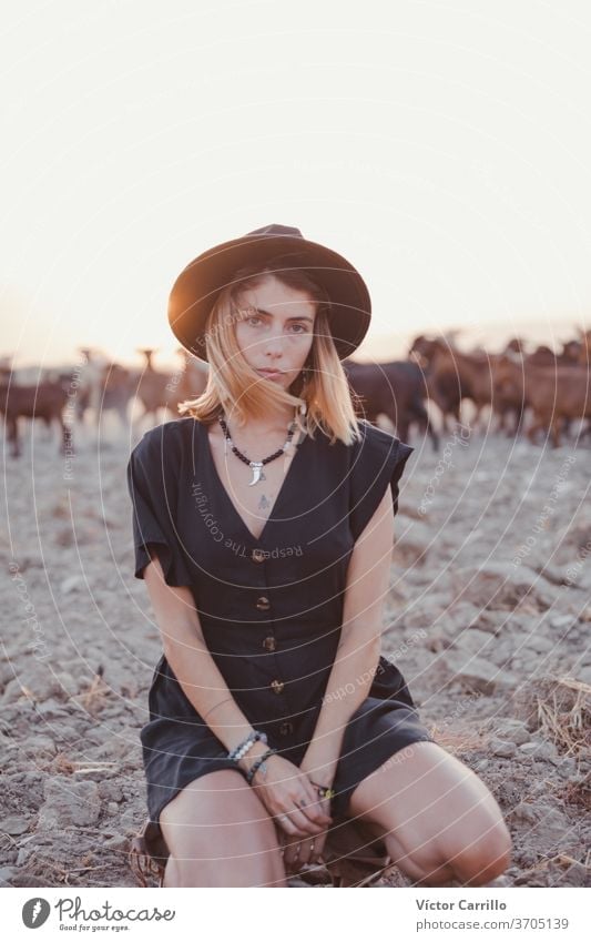 Young woman in a green dress and a hat in a solitary field in the countryside with goats in the background landscape freedom woman water adult alive yoga air