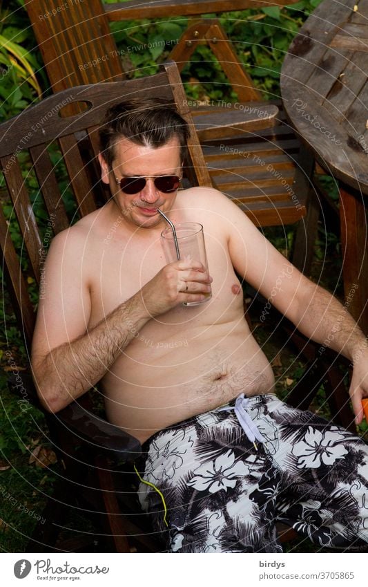 Man with sunglasses and free upper body enjoys a drink outside Summer Warmth free torso Drinking To enjoy Sunglasses Aviator goggles Straw sedentary Garden