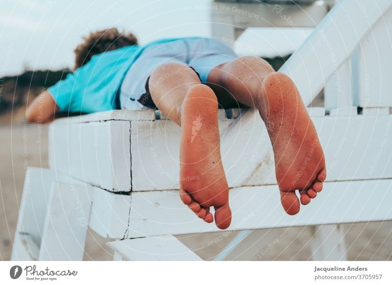 Boy lies barefoot on a chair on the beach Boy (child) Child Beach Legs feet Summer Barefoot Sand Exterior shot Toes Vacation & Travel Ocean Relaxation