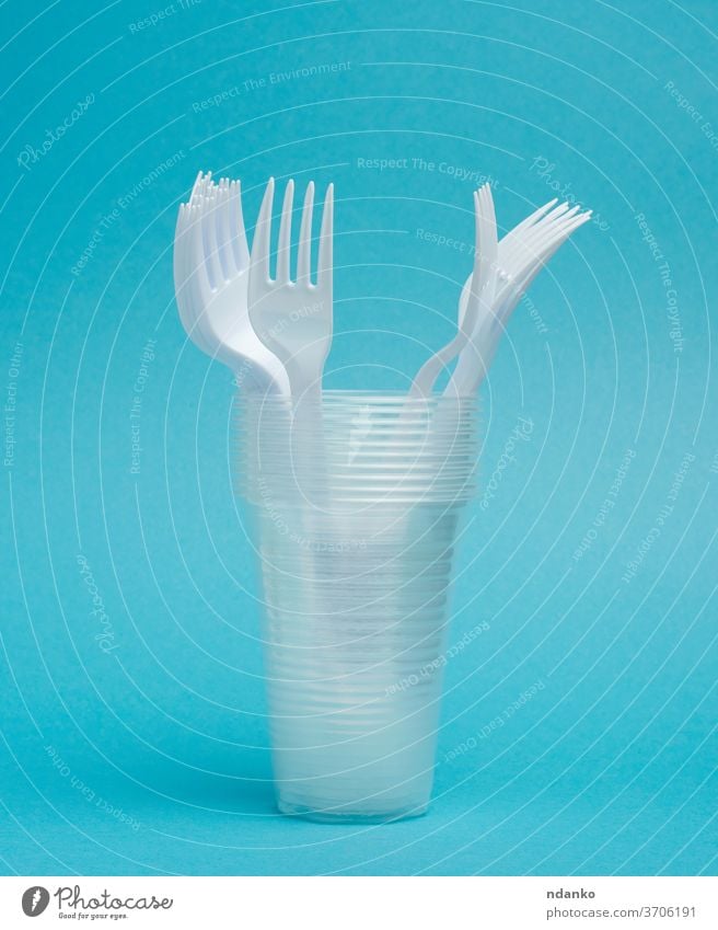 disposable plastic cups, forks on a blue background circle closeup cutlery dinner dinnerware dish dishware drink empty equipment food kitchen kitchenware knife
