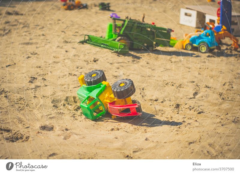 Toy tractor in the sandbox. Outside playing with sand toys. Sand toys Tractor Toys toy tractor Playing Infancy Sandpit Kindergarten Playground Summer