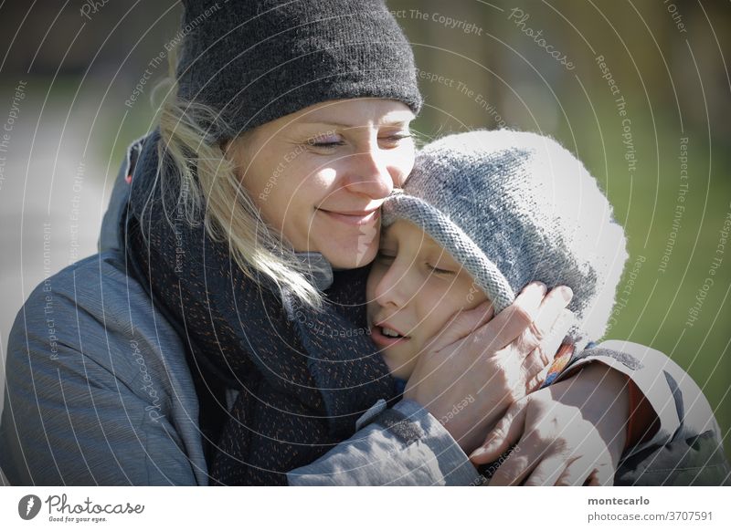 Young woman holds and hugs her son tenderly Exterior shot Generation Child Affection Woman Mother Son luck Responsibility portrait Day Calm Colour photo