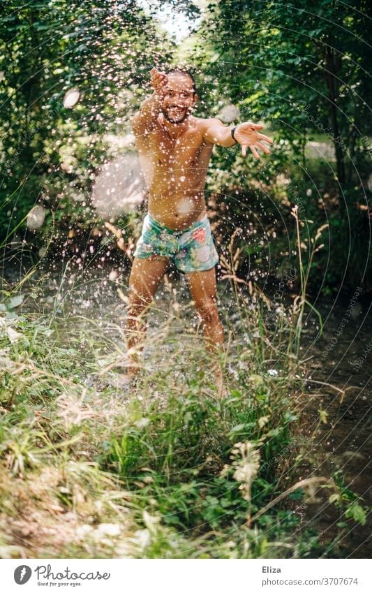 A man bathes in a stream in summer and splashes with water. Refreshing cooling off in this heat. Man Inject Summer Water splashing Refreshment Joy Wet