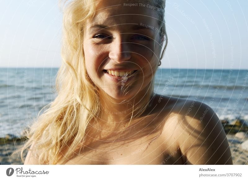 Portrait of a young blonde woman in front of the Baltic Sea Young woman Woman girl 18-20 years Blonde Slim already Curly sensual natural green eyes long hairs