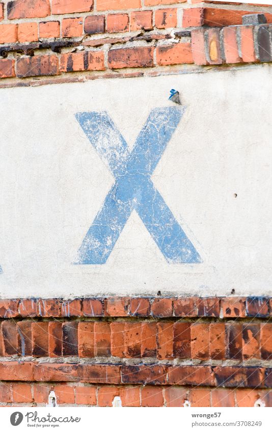 Large weathered blue X on a white wall stripe Letters (alphabet) blue paint Roman numerals white background Wall (building) Deserted Digits and numbers