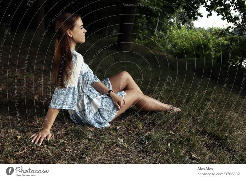 Portrait of a young woman in white-blue patterned summer dress in nature Light Athletic Feminine Emotions emotionally portrait Central perspective