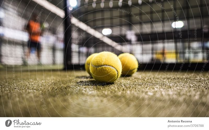 Paddle tennis balls in court paddle tennis padel sport game tournament man blurred indoors fences objects recreation leisure training sphere grass turf set net