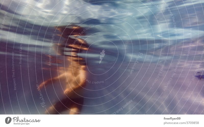 underwater view of people enjoying a swimming pool blue bathing drowning texture wave rippled infinite background salt water sunlight aquatic ocean ray below
