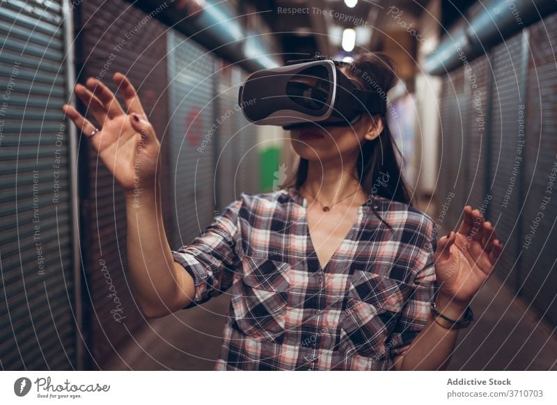 Woman in glasses of virtual reality in city vr woman experience grunge underground touch technology goggles using female shabby street narrow calm simulate