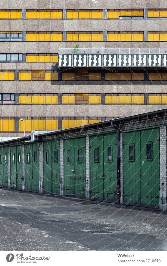 A series of garages in front of an administrative building with an original balcony Wooden gates doors Row Old Facade Window Closed Balcony Pattern Berlin