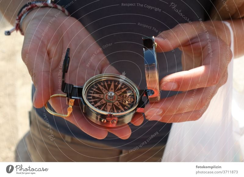 two hands holding a small compass Compass (Navigation) Direction groundbreaking Change in direction Orientation Compass point Road marking Clue Recommendation