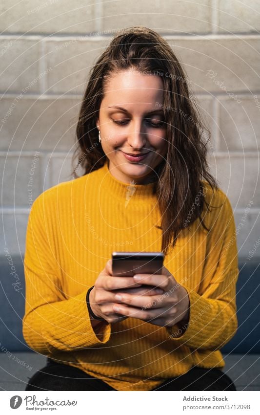 Young woman using on smartphone happy young casual mobile communicate satisfied female news modern loft device gadget connection concentrated browsing focus