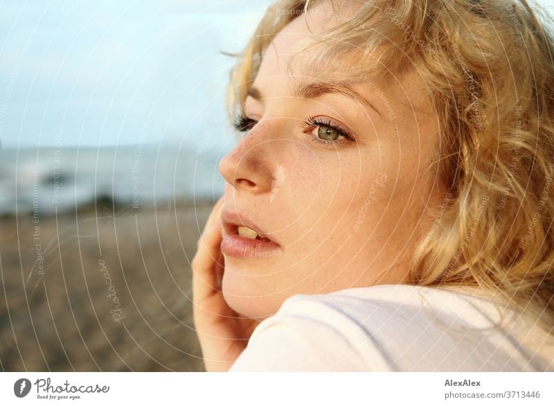 Portrait of a young blonde woman in front of the Baltic Sea Young woman Woman girl 18-20 years Blonde Slim already Curly sensual natural green eyes long hairs