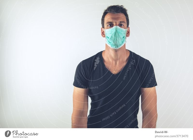 young man with breathing mask looks into the camera corona coronavirus pandemic Respirator mask Mask Authentic real lose patience Virus Illness Healthy
