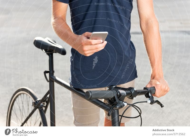 Man walking with bike while on the mobile phone man bicycle blond business casual caucasian cellphone communication cycling cyclist freelance gadget lifestyle