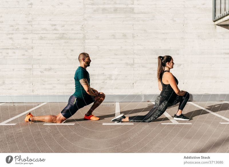 Sportive couple warming up before workout warm up training stretch body together athlete flexible sportswear healthy activity wellbeing stand lunge sportswoman